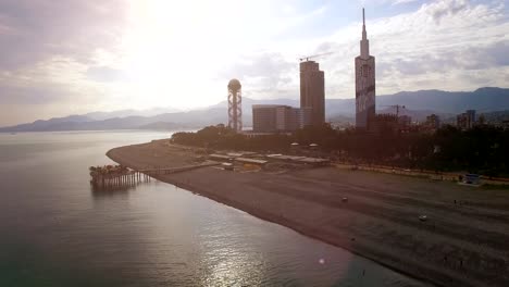 Light-haze-surrounding-Batumi-seafront-with-buildings-at-back,-late-afternoon