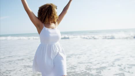 Plus-tamaño-étnica-femenina-remando-descalzo-en-la-playa