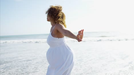 Afro-hair-Ethnic-female-paddling-barefoot-in-ocean