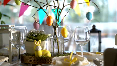 Young-woman-setting-easter-festive-table-with-bunny-and-eggs-decoration