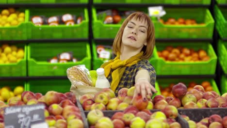 Frau-im-Rollstuhl,-die-Äpfel-im-Supermarkt-zu-kaufen