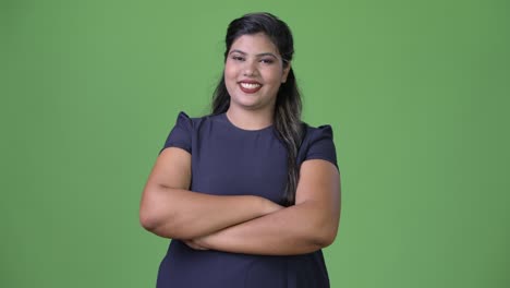 Young-overweight-beautiful-Indian-businesswoman-against-green-background