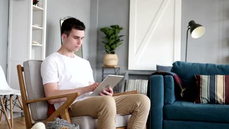 Man-Browsing-and-Scrolling-on-Tablet