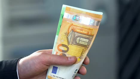 Männliche-Hände-erzählt-sein-Gehalt-hält-Euro-Scheine,-Haushaltskürzung-und-Ökonomie