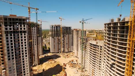 Construction-of-houses.-Drone-fly-over-construction-site-with-tower-cranes