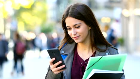 Schüler-zu-Fuß-und-überprüft-Telefon-in-der-Straße