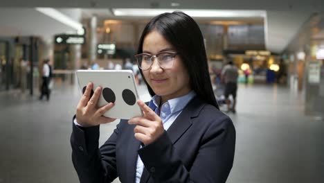 Empresaria-asiática-trabajando-en-una-tableta-digital-en-el-aeropuerto