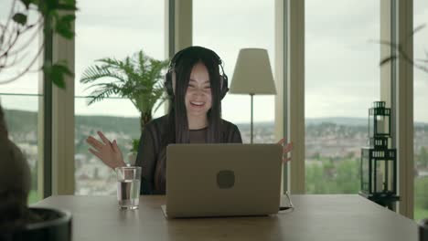 Young-woman-sitting-at-home-working-with-computer-and-chair-dancing