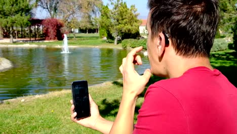 Young-boy-communicating-with-sign-language--at-smart-phone