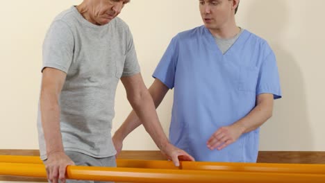 Physiotherapeuten-unterstützen-ältere-Mann-lernen,-zu-Fuß