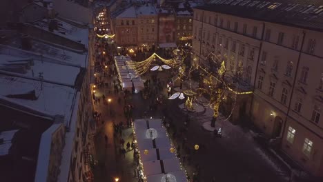 Lviv,-Ucrania---25-de-diciembre-de-2018.-Tiro-de-Arial.-Invierno.-Calle-plaza-Rynok.-Feria-de-Navidad.-Ayuntamiento-de-Lvov,-Consejo-de-la-ciudad.-Personas-están-caminando-en-el-centro-de-la-ciudad.-Adornos-navideños-y-luces.-Noche