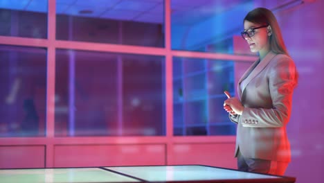 The-businesswoman-working-with-a-virtual-screen-on-the-hologram-background