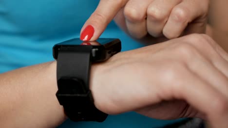 Frau-mit-ihrem-Touchscreengerät-tragbare-Technologie-Smartwatch.-Mädchen-machende-Gesten-auf-einem-tragbaren-Smartwatch-Computergerät-hautnah.