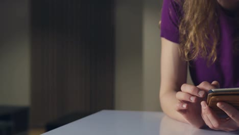 Panning-shot-of-woman-using-smartphone-in-apartment