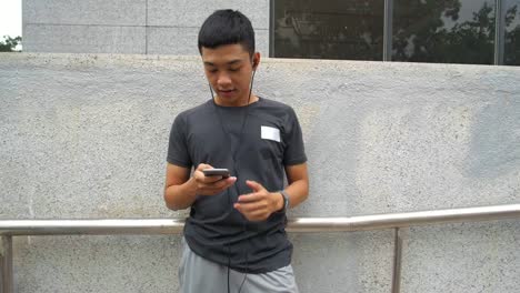 Asian-Man-Using-Smartphone-Outdoors