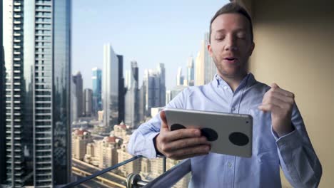 Caucasian-man-using-digital-tablet-for-internet-and-communications-with-cityscape-background