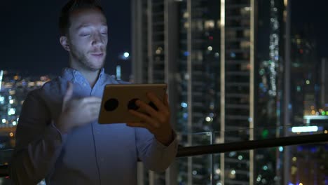 Caucasian-man-using-digital-tablet-for-internet-and-communications-with-cityscape-background