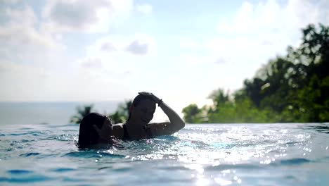 Two-girls-playing-in-the-outdoor-pool-on-a-sunny-day