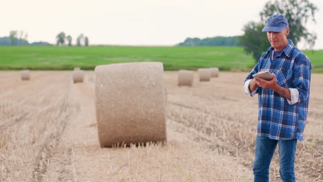 Moderne-Landwirtschaft.-Die-Liebe-zur-Landwirtschaft.-Landwirt-mit-digitalem-Tablet-bei-der-Prüfung-von-Bauernhof