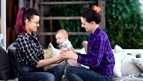 Female-parents-enjoying-playing-with-little-cute-son-smiling-and-relaxing-together-at-home