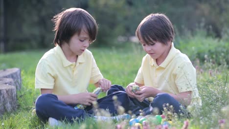 Sweet-children,-boy-brothers-with-bunny-ears,-egg-hunting-for-Easter,-child-and-Easter-day-traditions.-Kids-and-holidays