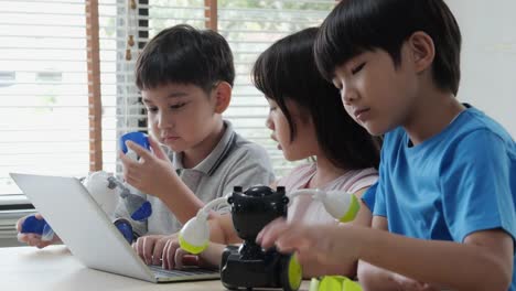 Junge-und-Mädchen-versuchen,-Roboter-im-Schulwissenschaftlichen-Club-zu-fixieren.-Projekt-für-Ingenieurclub-in-der-Schule.-Menschen-mit-Technologiekonzept.