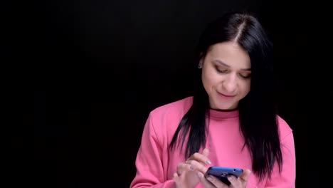 Retrato-en-primer-plano-de-la-joven-hermosa-mujer-caucásica-usando-el-teléfono-reaccionar-a-las-redes-sociales-mensajes-riendo-y-mirando-a-la-cámara