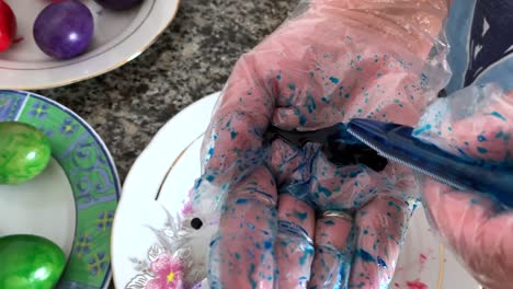 A-woman-in-gloves-paints-eggs