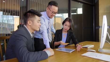 Asiatische-Geschäftsleute,-die-Tablet-verwenden