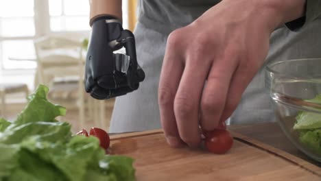 Mann-mit-myoelektrischen-Prothesen-arm-schneiden-Tomaten