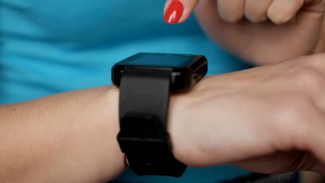 Frau-mit-ihrem-Smartwatch-Touchscreen-tragbare-Technologie-Gerät.-Frau-mit-ihrem-Smartwatch-Touchscreen-tragbare-Technologie-Gerät.-Mädchen-machen-Gesten-auf-einer-tragbaren-Smartwatch,-aus-nächster-Nähe.