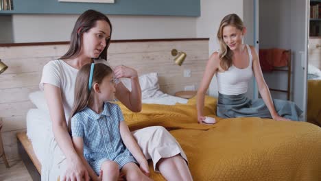 Same-Sex-Female-Couple-At-Home-In-Bedroom-Getting-Daughter-Ready-For-Schoolæ