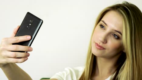 Hermosa-mujer-rubia-mirando-su-teléfono-celular,-tomando-un-selfie-en-un-café.-4K