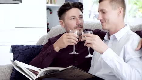 Gay-couple-relaxing-on-couch.-Toast-together.