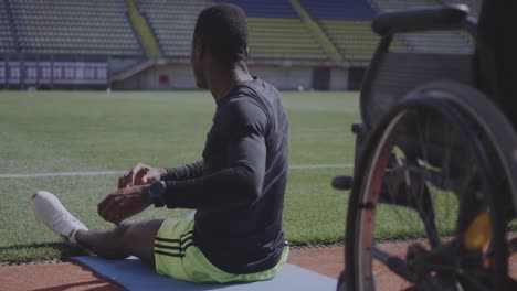 Athlete-sitting-on-ground-and-warming-up