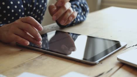 Mujer-de-negocios-escribiendo-en-la-tableta-digital-teclado-electrónico-en-la-mesa