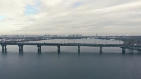 Verkehr-auf-einer-Brücke-über-einen-breiten-Fluss-im-Winter