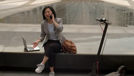 Asiatische-Frau-mit-Telefongespräch-im-Freien