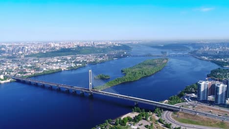 Luftdrohne-der-Südbrücke,-der-Stadt-Kiew.-Ukraine.-Dnjepr,-die-Brücke-überquert-den-Fluss.-Stadtbild-Luftbild-Brücke-auf-dem-Fluss-zwei-Jungs-klettern-auf-die-Spitze-der-Brücke