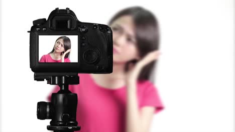 Asian-American-woman-having-eureka-moment-on-camera,-creating-content-for-social-media