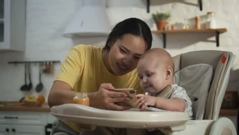 Mutter-zeigt-Smartphone-zu-Baby