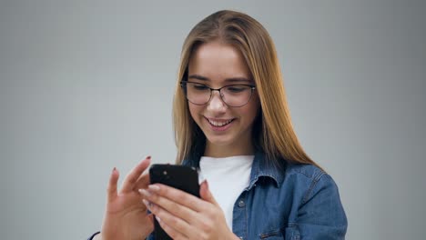 Hermosa-joven-usando-el-teléfono-inteligente-en-la-oficina