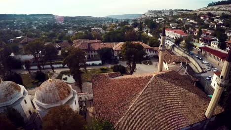 Aerial-view-on-the-old-city-with-church-before-sunset,-sunrise.-Fog,-Cloudy-sky.-Bahchisarai,-Crimea,-Russia.