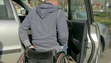 Hombre-discapacitado-en-silla-de-ruedas,-tullido-tratando-de-llegar-en-coche,-mostrando-problemas-que-enfrentan-los-usuarios-de-silla-de-ruedas-en-situaciones-cotidianas