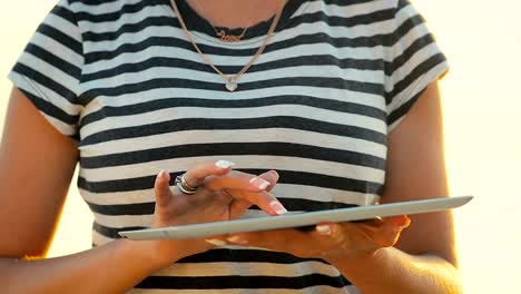 Close-up-girl-uses-a-tablet-to-communicate-in-social-networks-in-a-trip-by-the-sea.