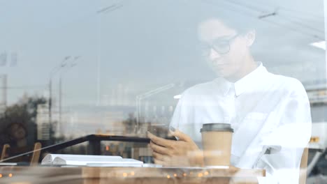 Woman-using-phone-at-cafe