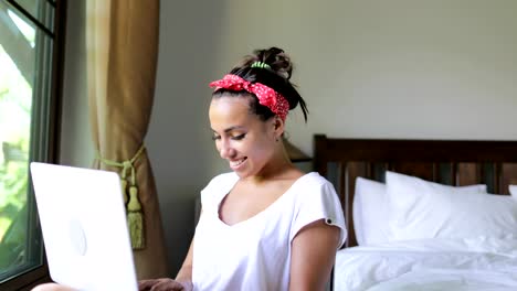 Young-Woman-Using-Laptop-Computer-Beautiful-Girl-Chatting-Online-In-Bedroom-Morning-Over-Big-Window