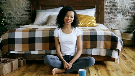 Attractive-mixed-race-girl-teenager-recording-video-blog-looking-into-camera-and-talking-to-her-followers-at-home