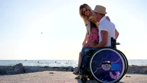 Behinderte-mit-schwangere-Frau-und-Tochter-zu-Fuß-Togetherhappy-Familie-kommuniziert-auf-Hintergrund-blauer-Himmel