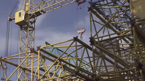 Metall-Profilen-der-demontierten-Baukran-auf-der-Straße.-Baumaschinen.-Gelbe-Metall-Konstruktionen.-Industriellen-Hintergrund